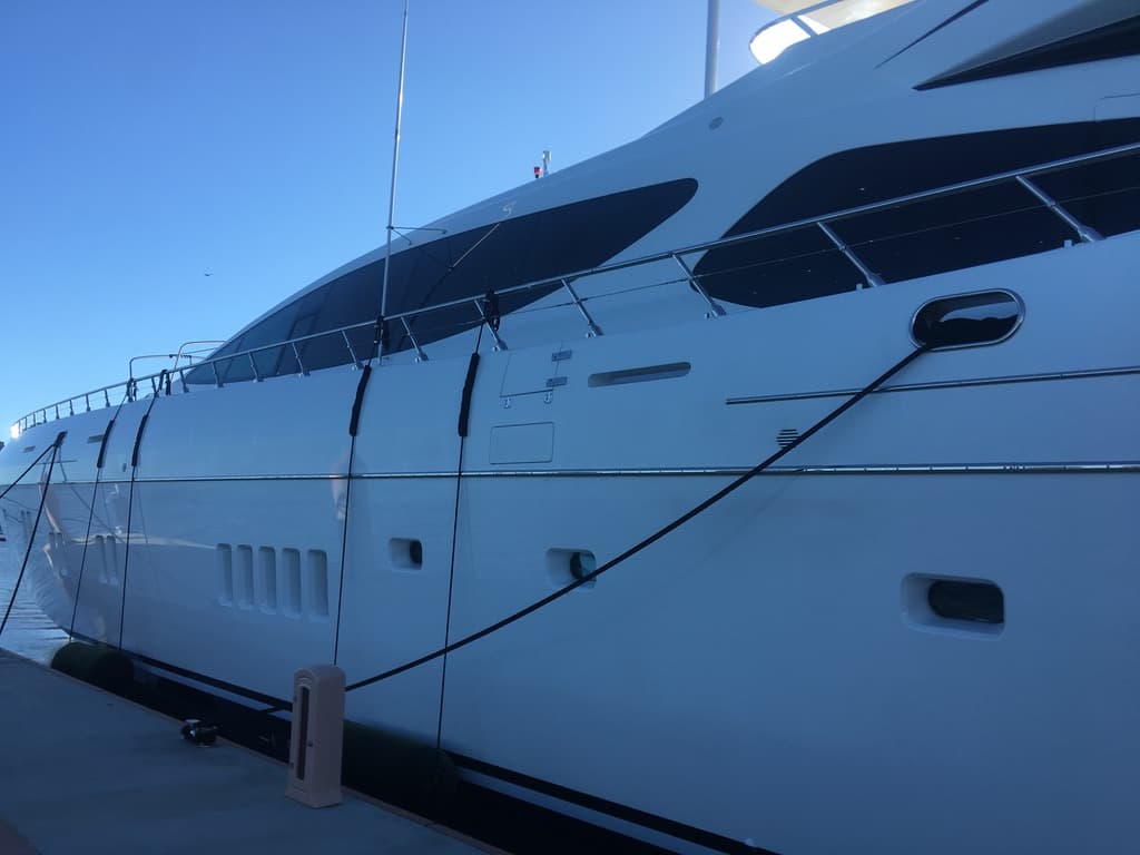 White motoryacht bow with dark marine windshield film against a clear sky
